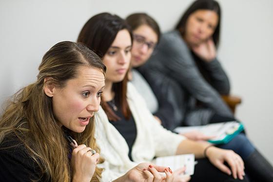 Photo of four women sitting in a row of chairs at a psychology counseling session at Chatham University.  