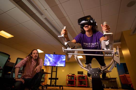图为身穿波胆网站紫色校服的学生, 在虚拟现实机里, 而一位教授在旁边看着