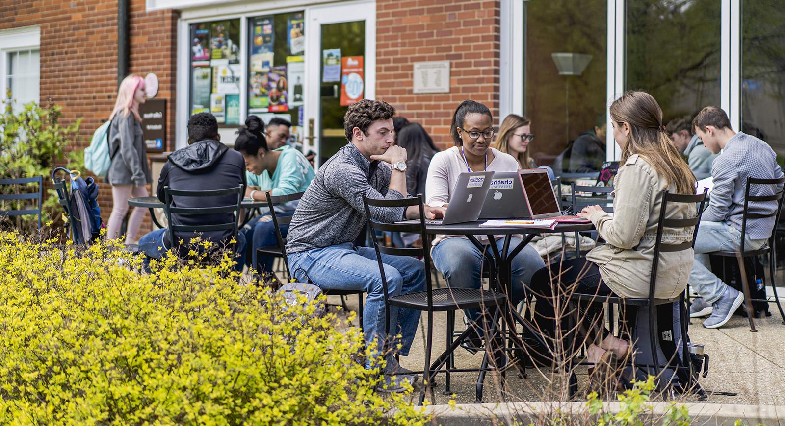 Photo of Chatham University students working on outdoor patio tables in front of Cafe Rachel on the Shadyside Campus.