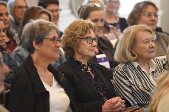 Photo of a group of women listening to an unseen speaker at an event